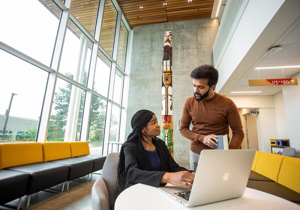 Two young people working at a laptop together