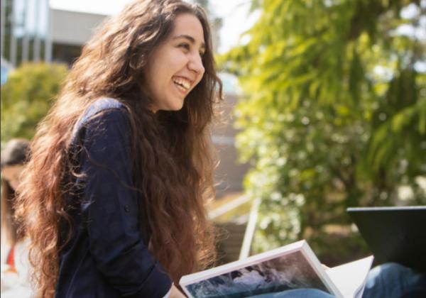 Happy student studying outside. 