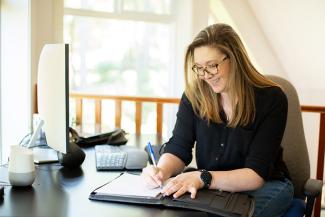 Woman writing at a desk. 